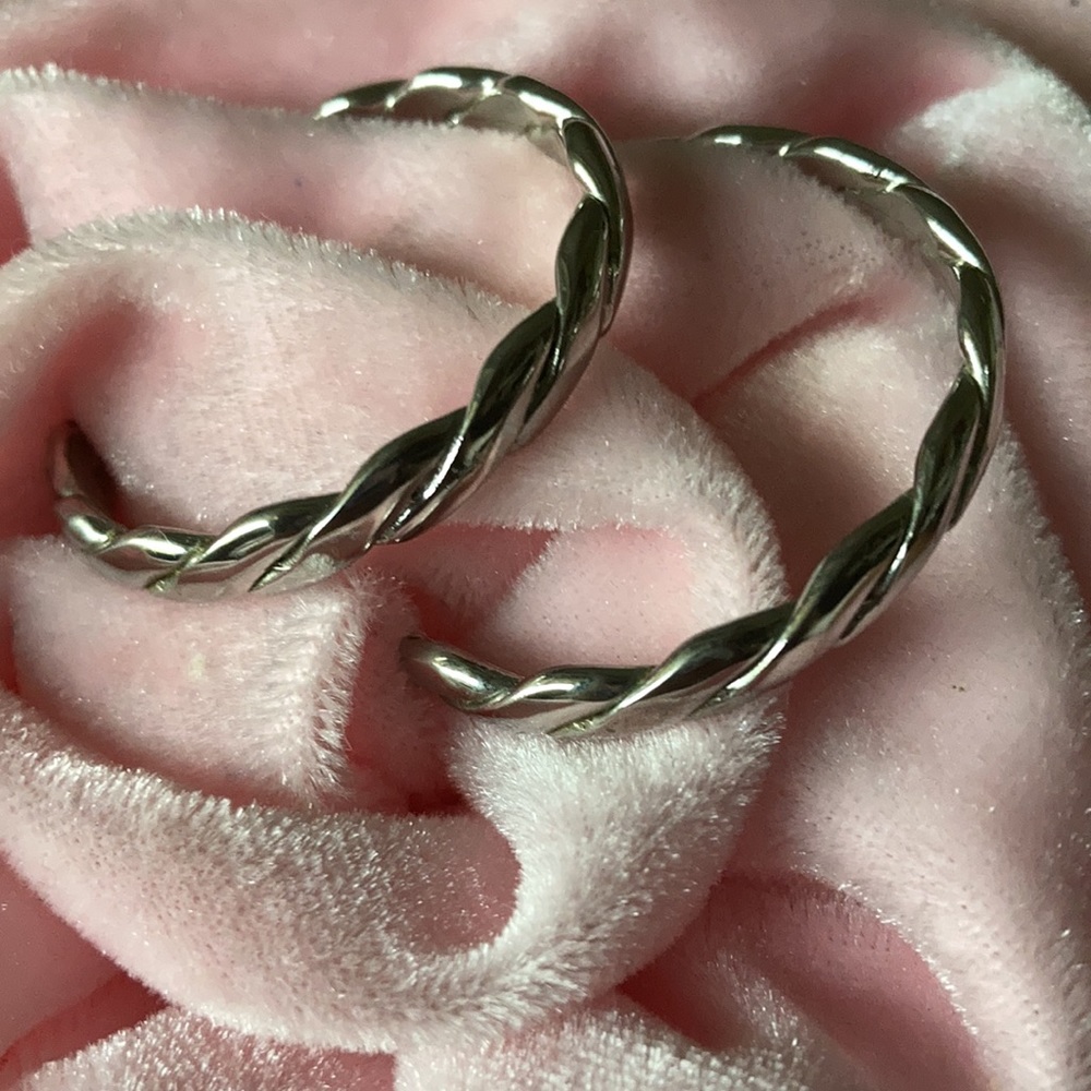 Braided silvery hoop earrings.